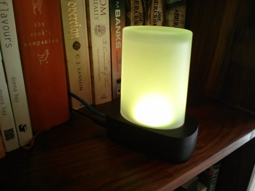 A light that indicates the forecast sitting on a bookshelf