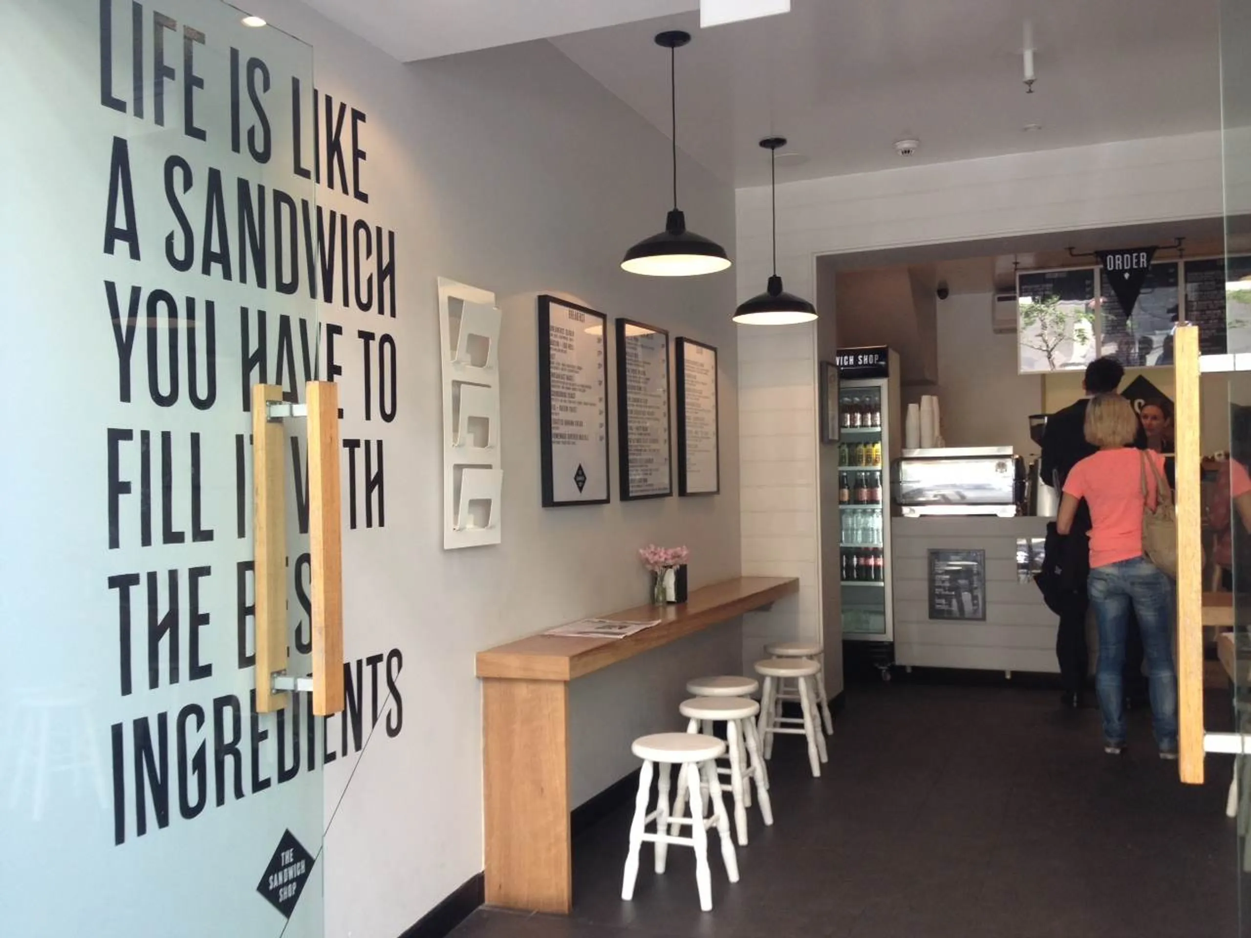 A sandwich shop with people queuing to buy food