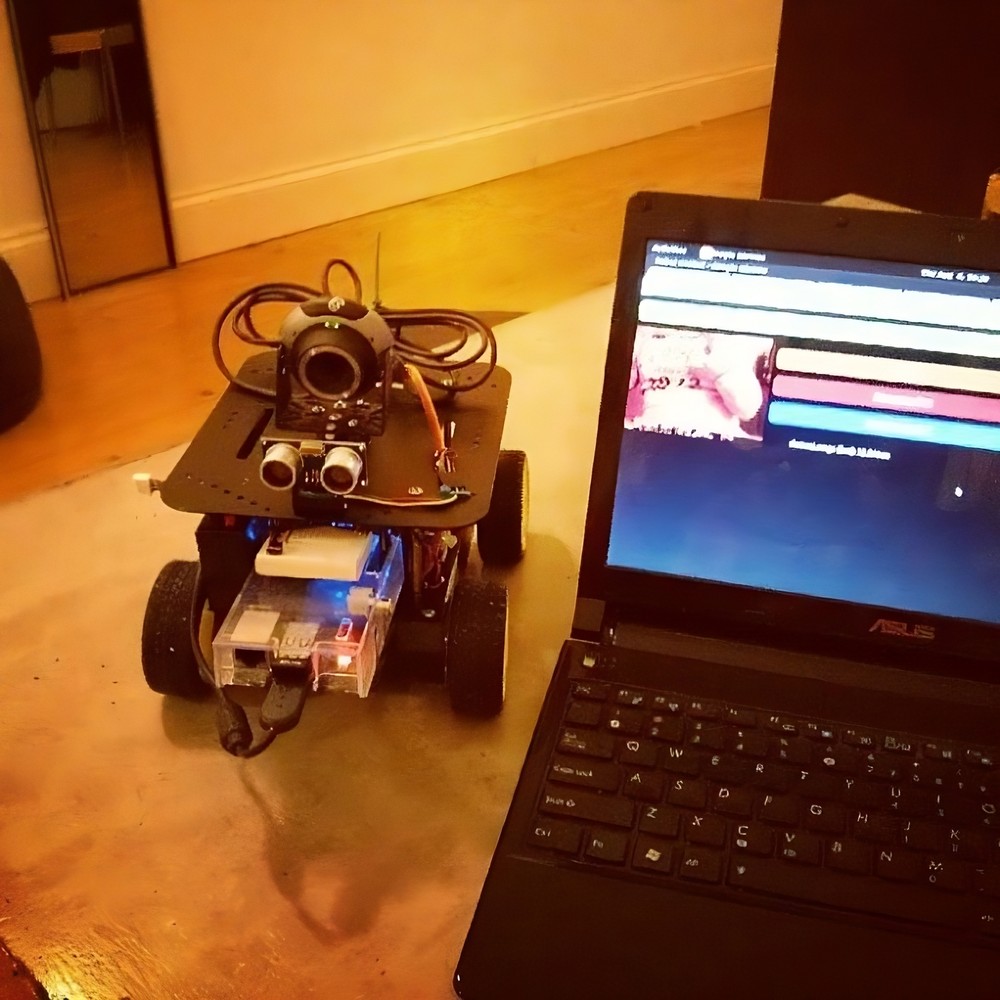 Small, wheeled robot next to laptop computer
